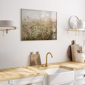 Vintage Spring wall art wildflower field landscape painting art print displayed in an antique frame, featuring pink and beige wildflowers up close. This Spring decor can also be Easter decor. The painting features intricate brushwork and colors. The shop name Lexington Prints is written below.