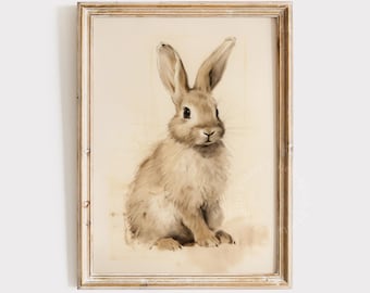 May include: A watercolor painting of a brown rabbit sitting on a white background. The rabbit has long ears and a fluffy tail. The painting is framed in a light wood frame.