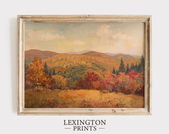 May include: An autumn landscape painting in a light wooden frame. The artwork depicts rolling hills and trees in shades of orange, red, and yellow, with a blue sky and clouds. The text "LEXINGTON - PRINTS -" is at the bottom.