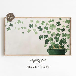 May include: A framed print featuring a green pot overflowing with gold coins and green shamrocks. The artwork has a cream-colored background with scattered shamrocks. The text "LEXINGTON PRINTS" and "FRAME TV ART" are at the bottom.