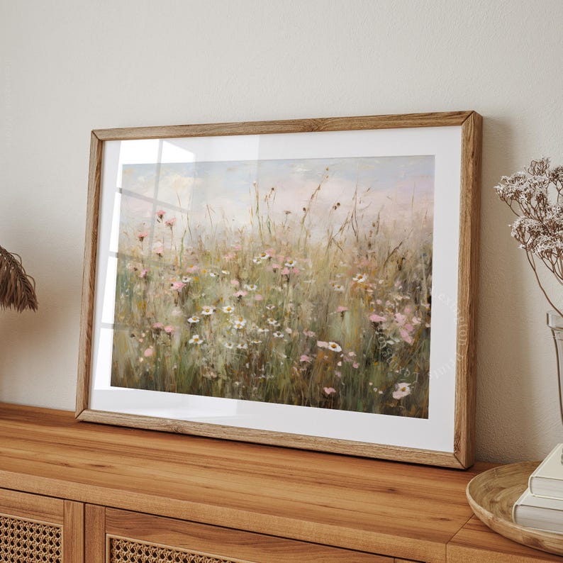 Vintage Spring wall art wildflower field landscape painting art print displayed in an antique frame, featuring pink and beige wildflowers up close. This Spring decor can also be Easter decor. The painting features intricate brushwork and colors. The shop name Lexington Prints is written below.