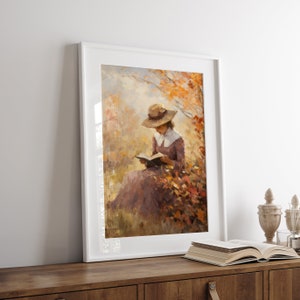 Vintage fall woman reading book fall painting oil painting art print displayed in an antique frame against a white background. The painting features intricate brushwork and colors. The shop name Lexington Prints is written out beneath the wall art.