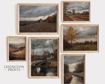 May include: A collection of framed landscape paintings featuring autumnal scenes with muted colors. The artworks depict fields, trees, and houses under dramatic, cloudy skies. The frames are a light wood color.