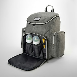 May include: A grey diaper backpack with multiple compartments, including two side pockets and a front flap. The backpack contains two baby bottles and a yellow item. The top of the bag has a zip closure and a handle.