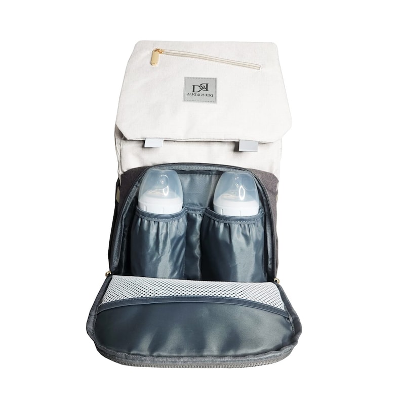 May include: A gray and white diaper bag with a zippered pocket on the front. The bag is open and has two clear baby bottles inside. The bag has a mesh pocket on the bottom and a gray lining.