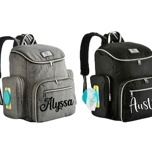 May include: Two diaper backpacks, one gray and one black, with multiple pockets and a top handle. The gray backpack has the name "Alyssa" in cursive, and the black backpack has the name "Austin". Both have a side pocket for wipes.