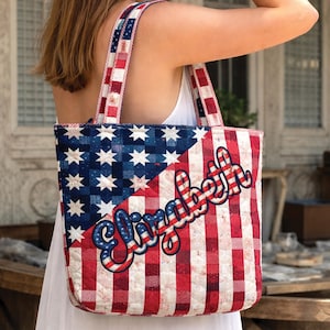 May include: A quilted tote bag with a patriotic design. The bag features a blue section with white stars and a red and white checkered pattern. The name "Elizabeth" is written across the front in a cursive font. The straps are red and white checkered.