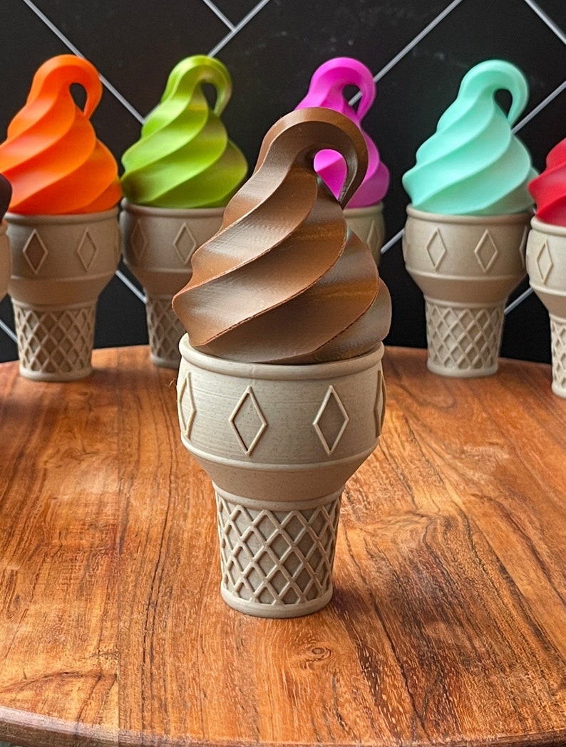 May include: A collection of ice cream cones with different colored scoops of ice cream. The cones are all white with a diamond pattern. The ice cream scoops are orange, green, pink, blue, and brown.