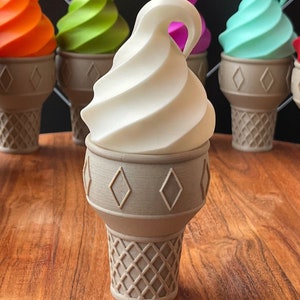 Op de afbeelding: Een witte swirl-ijscone met een bruine wafeltje. Het ijs is in de vorm van een swirl en staat op een houten tafel. Er zijn andere ijscones op de achtergrond, maar die zijn wazig.