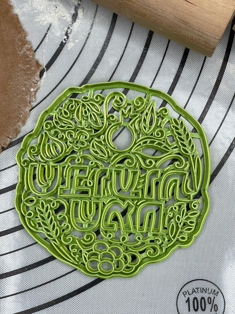May include: Green plastic cookie cutter with a floral design and the words "Happy Summer" in a decorative font.