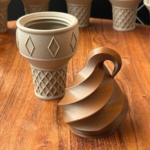 May include: A brown swirl-shaped ice cream cone with a beige waffle cone.