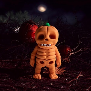 Puede incluir: Una figura de calabaza esquelética con una sonrisa de dientes, de pie sobre un lecho de hojas y ramitas marrones. La calabaza es naranja con un tallo verde y ojos blancos. El fondo es un bosque oscuro con luna llena.