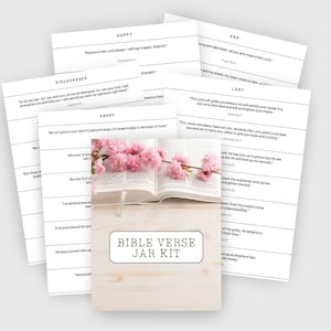 May include: A Bible Verse Jar Kit with printed cards categorized by emotions like Happy, Sad, and Angry. An open book with pink flowers rests on a wooden base with the text "Bible Verse Jar Kit".