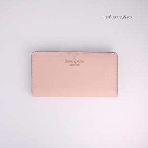 Cartera plegable grande y delgada Madison de Kate Spade en color rosa caracol