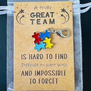 May include: A gift bag containing a card with the text "A truly GREAT TEAM IS HARD TO FIND, Difficult to part with AND IMPOSSIBLE TO FORGET." A puzzle piece charm is attached.