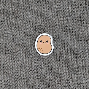 Puede incluir: Una patata de dibujos animados marrón con una cara feliz y un contorno blanco. La patata tiene algunas manchas marrones.