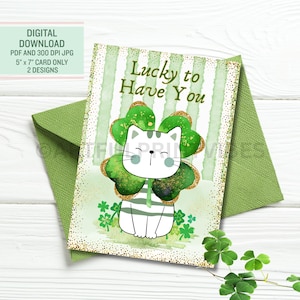 Puede incluir: Una tarjeta de felicitación del Día de San Patricio con un gato de dibujos animados dentro de un trébol de cuatro hojas. La tarjeta dice "Lucky to Have You" y va acompañada de un sobre verde. La tarjeta mide 12,7 cm x 17,8 cm y es una descarga digital.