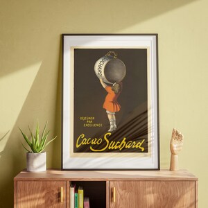 May include: Vintage poster advertising Cacao Suchard chocolate. A young girl holds a large can of cocoa over her head. The text on the can reads "Suchard". The poster also includes the text "Dejeuner par excellence Cacao Suchard".