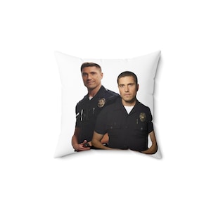 Può includere: Due uomini in uniforme da polizia stanno uno accanto all'altro. L'uomo a sinistra indossa un'uniforme blu scuro con un distintivo sul petto sinistro. L'uomo a destra indossa un'uniforme simile con un distintivo sul petto destro.