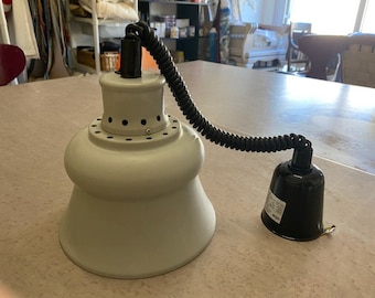 May include: A white pendant light with a black cord and a black socket. The light has a round, bell-shaped shade.