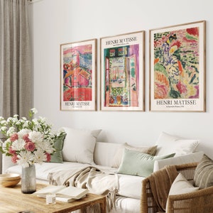 K&ouml;nnte beinhalten: Drei gerahmte Kunstdrucke mit abstrakten Gem&auml;lden von Henri Matisse. Die Drucke befinden sich in einem Wohnzimmer mit einem wei&szlig;en Sofa und einem Holz-Couchtisch.