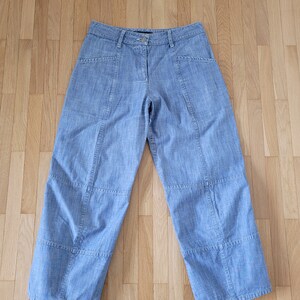May include: Light blue denim pants with multiple pockets and a straight leg silhouette.