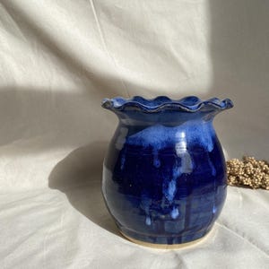 Può includere: Una tazza di ceramica bianca con manico nero e la scritta "But First, Coffee" in stile scritto a mano. La tazza è su una superficie bianca. La tazza è alta circa 10 cm.