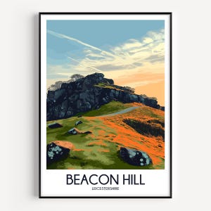 May include: A framed art print featuring a stylized landscape of Beacon Hill in Leicestershire. The image depicts a rocky outcrop on a grassy hill under a blue and orange sky. The text BEACON HILL LEICESTERSHIRE is printed at the bottom.