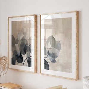 Könnte beinhalten: Ein Konsolentisch aus Holz mit zwei gerahmten abstrakten Blumendrucken, einem Stapel Bücher und einem offenen Buch darauf. Der Tisch hat eine helle Holzoptik und gedrehte Beine.