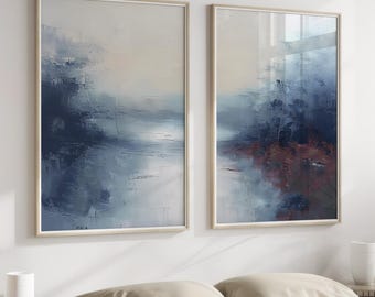 Puede incluir: Dos pinturas abstractas en tonos azules y blancos con un toque de rojo en la pintura de la derecha. Las pinturas están enmarcadas en un marco de madera claro y están colgadas en una pared blanca.