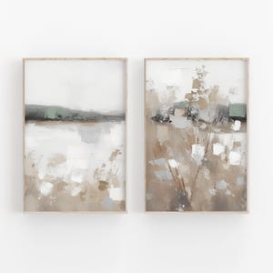 Pode incluir: Duas pinturas abstratas de paisagens em tons de marrom, branco e verde. As pinturas são emolduradas em uma moldura de madeira clara e estão penduradas em uma parede branca.