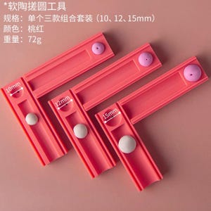 Könnte beinhalten: Rosa Tonformwerkzeuge mit den Maßen 10 mm, 12 mm und 15 mm. Jedes Werkzeug hat einen Kanal mit einer weißen Kugel darin. Der Text auf dem Bild ist auf Chinesisch.