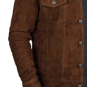May include: A brown suede jacket with a button-up front and multiple pockets. The jacket has a classic denim style.