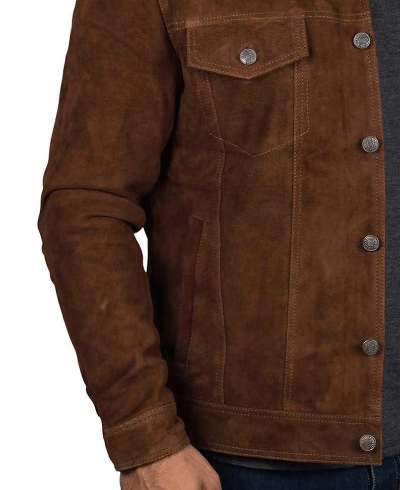 May include: A brown suede jacket with a button-up front and multiple pockets. The jacket has a classic denim style.