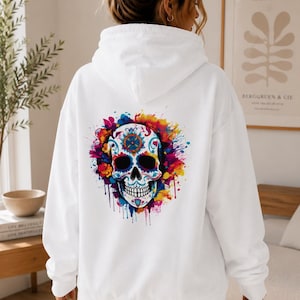 May include: White hoodie featuring a colorful sugar skull design on the back. The skull is decorated with floral and geometric patterns in shades of blue, yellow, pink, and orange. The word "White" is visible in the top left corner.