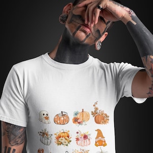 May include: White t-shirt featuring a range of pumpkin and autumn-themed illustrations, including a ghost, a gnome, and the word "BOO!"
