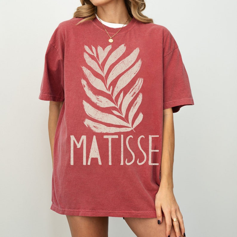 May include: A red oversized t-shirt with a white stylized leaf design and the text "MATISSE" printed on the front.