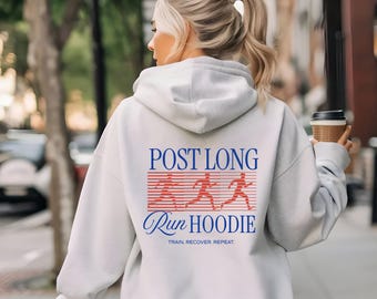 May include: A light gray hoodie with the text "POST LONG RUN HOODIE" in blue and red. The design includes running figures. The phrase "TRAIN. RECOVER. REPEAT." is printed below the main text.