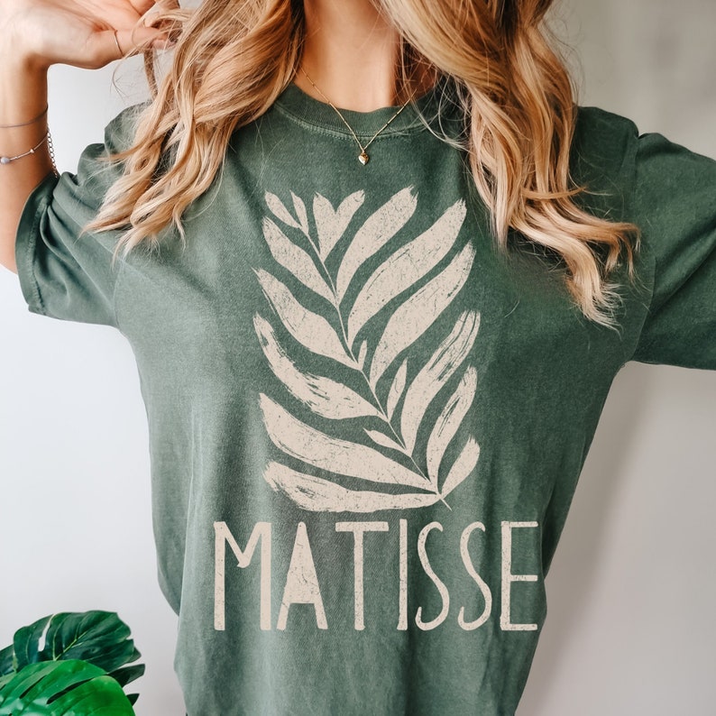 May include: A green t-shirt with a white stylized leaf design and the word "MATISSE" printed on the front.