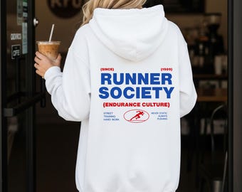 May include: White hoodie with the text "RUNNER SOCIETY" in blue, with red accents. The hoodie includes the text "(ENDURANCE CULTURE)" and a running figure graphic. The hoodie also has the text "STREET TRAINING HARD WORK" and "NEVER STATIC ALWAYS PUSHING".