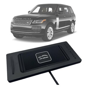 Puede incluir: Almohadilla de carga inalámbrica para automóvil negra con el texto "CAR WIRELESS" y "RANGE ROVER" impreso en la almohadilla. La almohadilla es rectangular con una superficie texturizada y una ranura en el lado izquierdo. Un SUV Range Rover negro en el fondo.