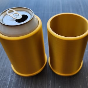 May include: Two gold-colored can coolers, one with a can inside. The can cooler is made of a smooth, textured material.