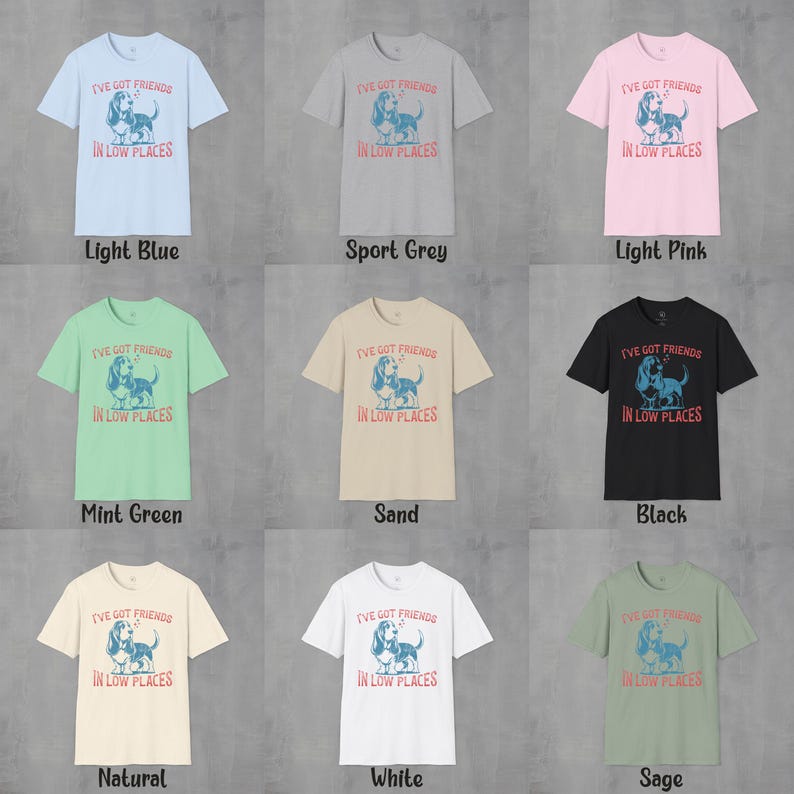May include: A set of ten t-shirts in various colors featuring a graphic of a dog with the text "I've got friends in low places". The colors include light blue, sport grey, light pink, mint green, sand, black, natural, white, and sage.