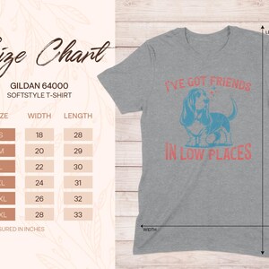 May include: Gray t-shirt with a blue and pink graphic of a basset hound with the text "I've got friends in low places". Size chart included with measurements in inches.