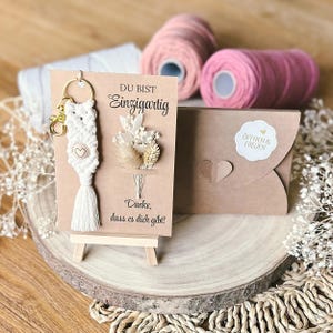 Grußkarte mit Makramee Schlüsselanhänger, Holzperle mit Gravur, Geschenkverpackung, Trockenblumen, Metallkarabinerhaken, Personalisiert