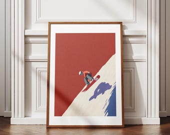 Puede incluir: Una impresión artística enmarcada que representa a un snowboarder en una pendiente nevada. La obra de arte tiene un estilo minimalista con un fondo rojo, una pendiente blanca y beige y una sombra azul. El snowboarder lleva una chaqueta roja y pantalones grises.