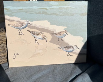 May include: A painting of four sandpipers on a beach with a blue and green ocean in the background. The painting is signed "gia" in the bottom left corner.
