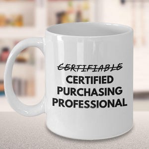 Peut inclure: Une tasse en céramique blanche avec une anse incurvée. La tasse présente le texte "CERTIFIABLE CERTIFIED PURCHASING PROFESSIONAL" en noir, avec une typographie stylisée. La tasse est conçue pour un professionnel ou quelqu'un dans le domaine des achats.