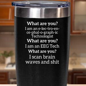 May include: Black insulated travel mug with a silver rim and lid. The mug has the text: "What are you? I am an e-lec-tro-en-ce-phal-o-graph-ic Technologist. What are you? I am an EEG Tech. What are you? I scan brain waves and shit."