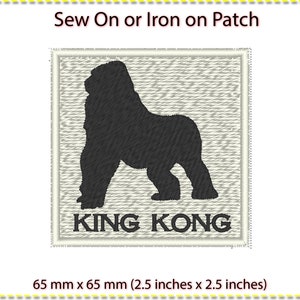 May include: A black and white embroidered iron-on or sew-on patch featuring a silhouette of King Kong with the text "KING KONG" below. The patch measures 2.5 inches by 2.5 inches.